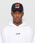 aftr99 | A model wearing a black baseball cap with a red, white, and black 'afr99' logo, paired with a white hoodie featuring a small black 'afr99' logo on the chest, against a light gray background.